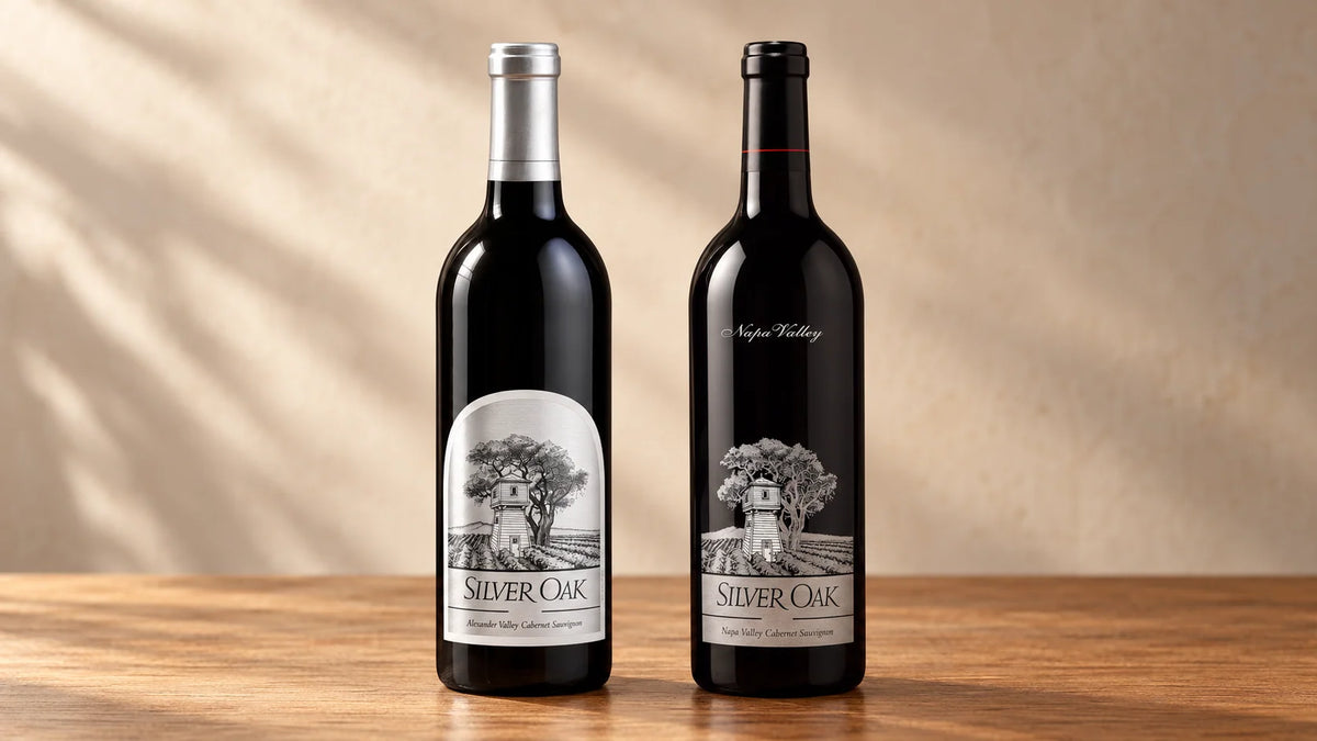 Silver Oak Alexander Valley and Napa Valley Cabernet Sauvignon bottles side by side on a wooden table.